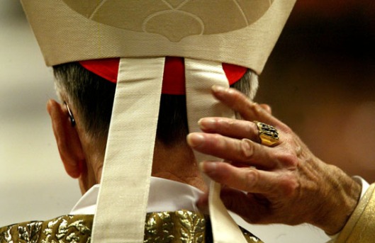 A Cardinal adjusts his mitria cap as he attendsthe celebration of the Easter Vigil service presided ..